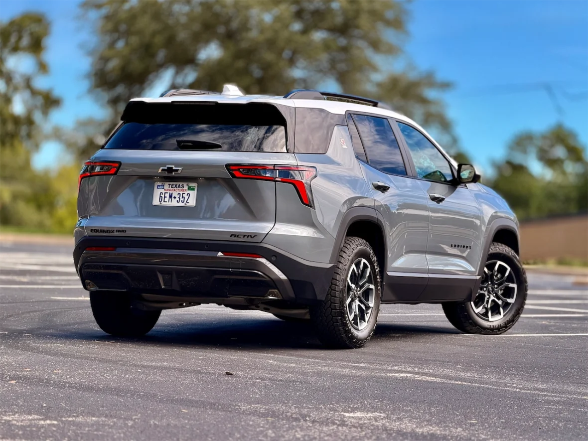 Rear view of a silver Chevrolet Equinox parked in an outdoor lot, showcasing its modern design and black alloy wheels.