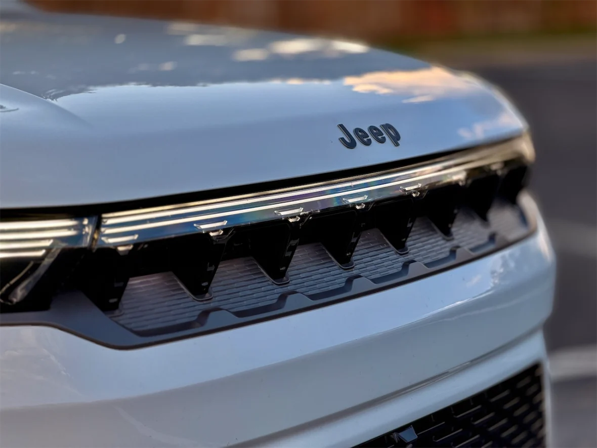 Close-up of a Jeep grille, showcasing the logo and distinctive design elements.