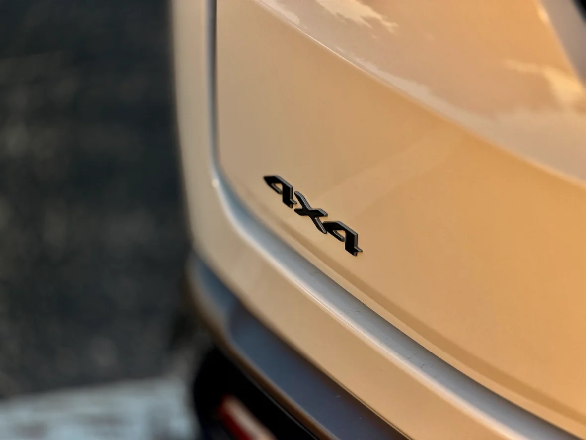 Close-up of a vehicle's rear badge displaying '4x4' on a beige background.
