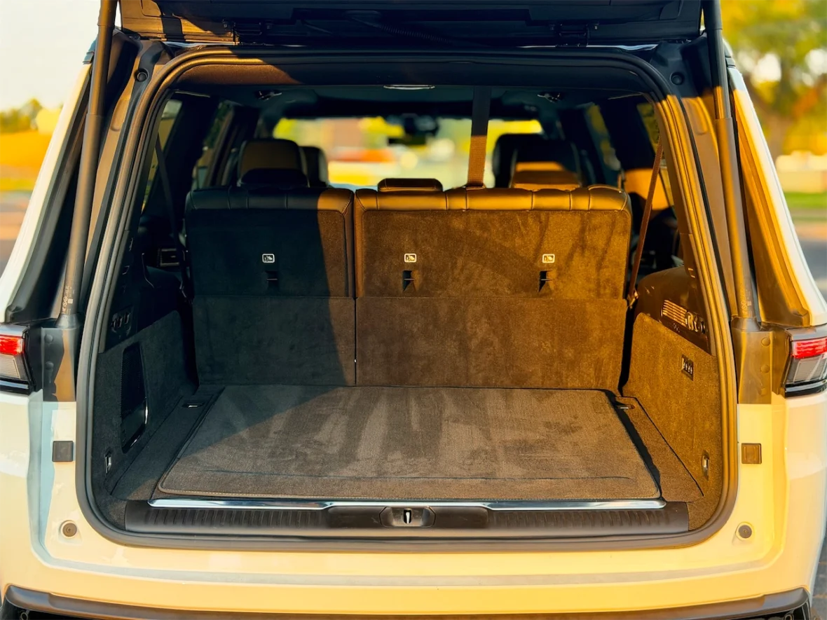 Interior of an SUV with the rear seats folded down, showing a spacious cargo area with a carpeted floor.