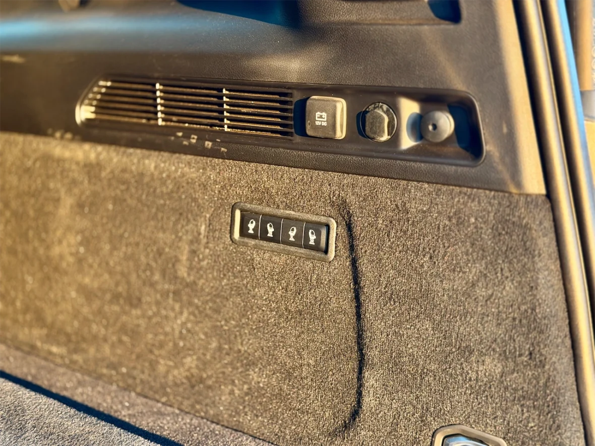 Interior view of a car featuring control buttons, air vents, and textured surfaces.