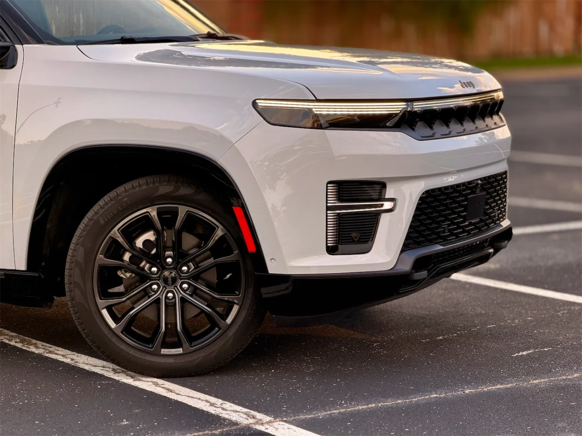 Close-up of the front left wheel and fender of the 2026 Jeep Grand Wagoneer L, featuring sleek black alloy wheels and stylish design elements.
