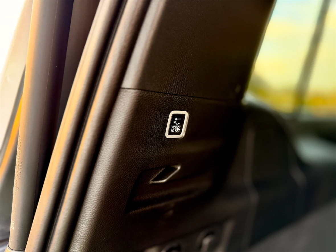 Close-up of a car interior detail showing a seat adjuster button labeled 'Fold to Set'.