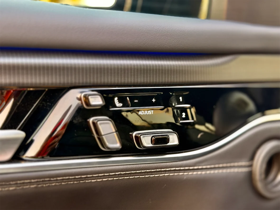 Close-up of car seat adjustment controls, featuring buttons for seat position, height adjustment, and memory settings.