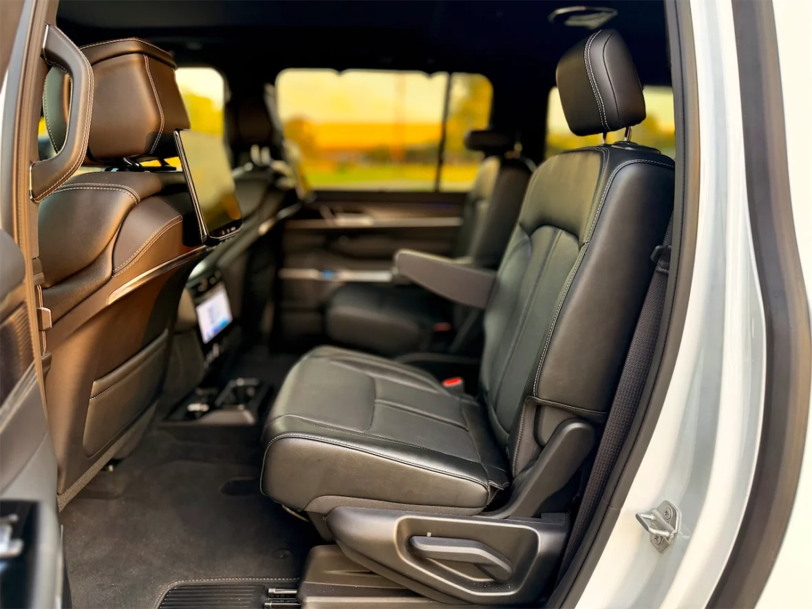 Interior view of a spacious vehicle showcasing two leather front seats and a rear entertainment system mounted on the back of the front seat.
