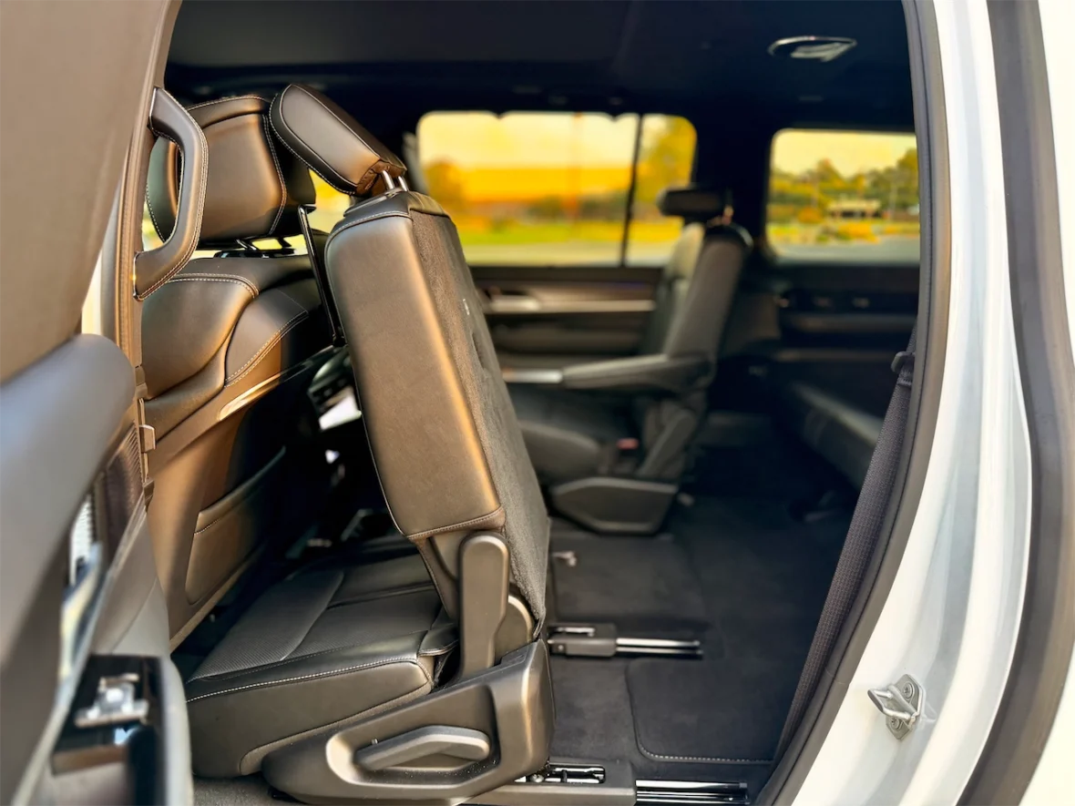 Interior view of a vehicle showcasing two folded rear seats, highlighting the leather upholstery and spacious cabin design.