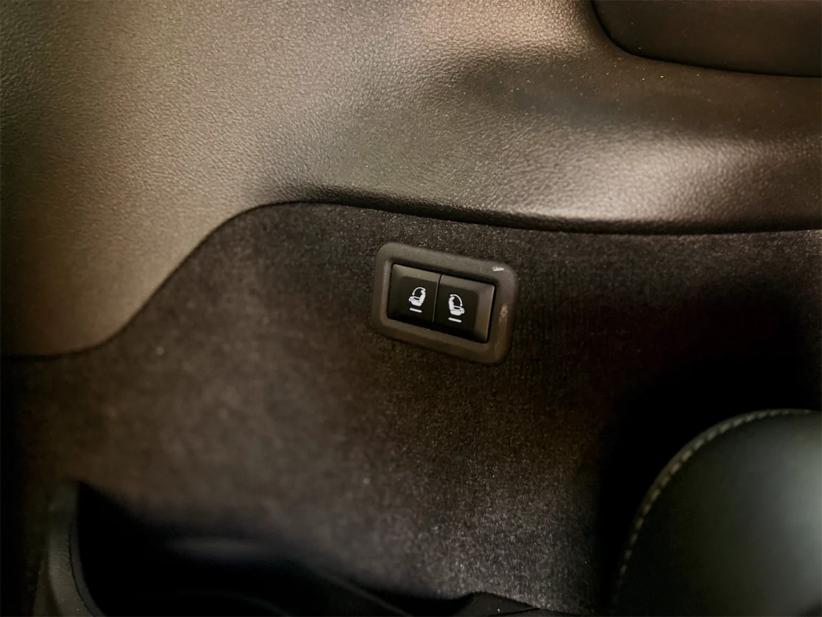 Close-up of car seat adjustment buttons located on the interior side panel.