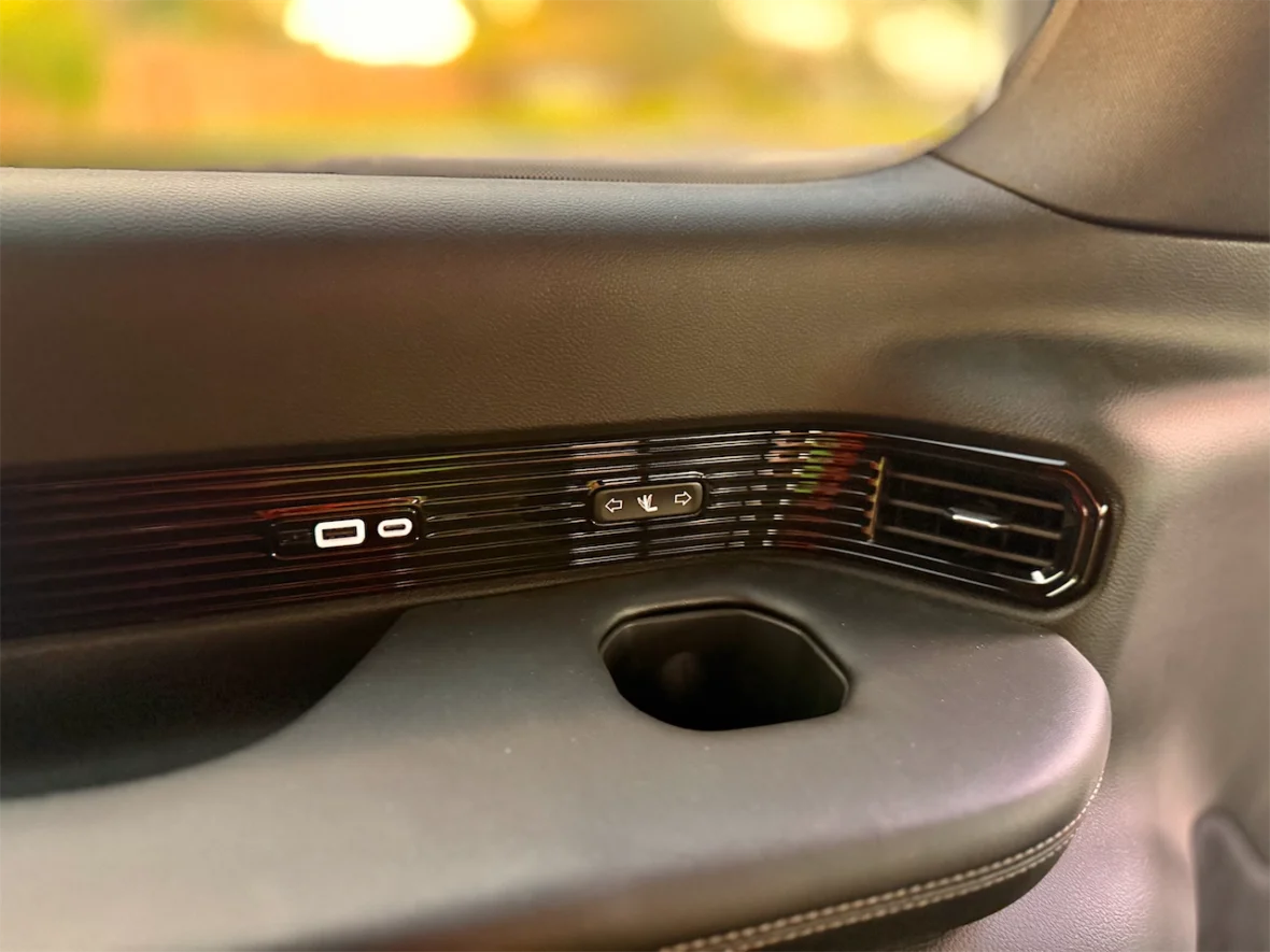 Interior shot of a car door panel featuring control buttons, USB ports, and air vents.