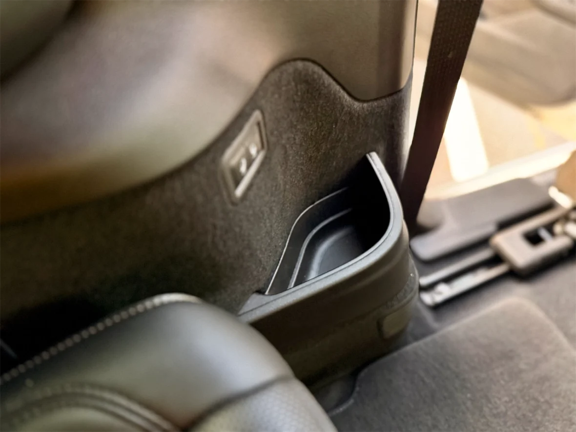 Interior detail of a car showing a cup holder and surrounding upholstery.