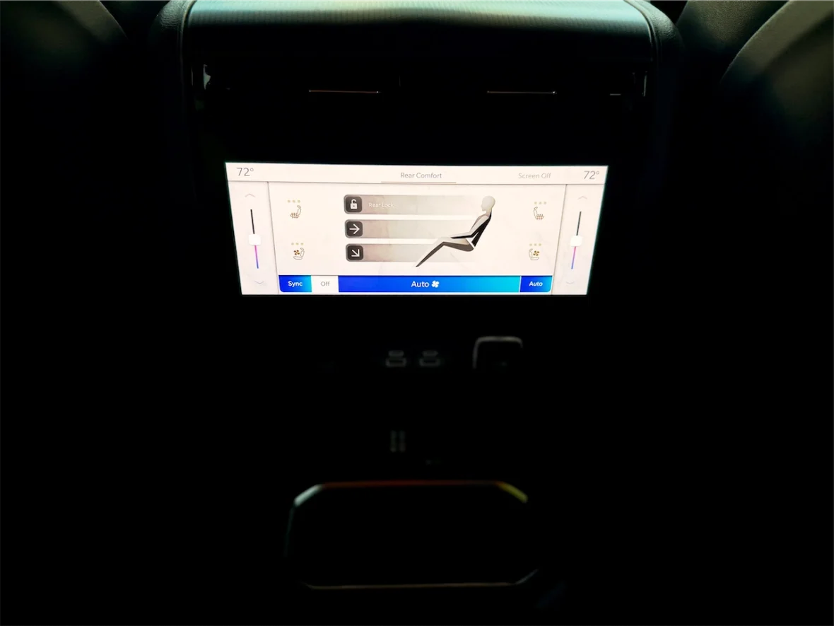 Car dashboard display showing rear comfort settings with temperature control and seat adjustment options.