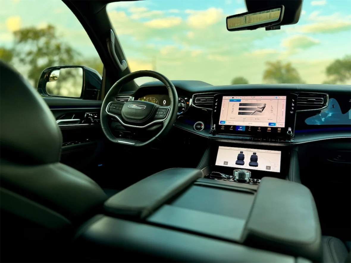 Interior view of a luxury vehicle showcasing a modern dashboard, steering wheel, and infotainment system with touchscreen displays.