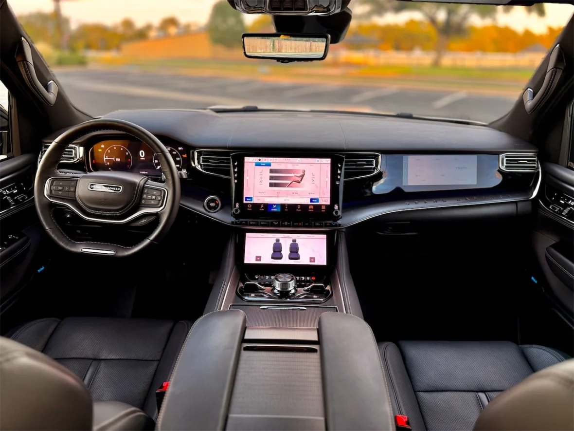 Interior view of a modern vehicle showcasing a sleek dashboard with multiple screens, a steering wheel, and leather seats.