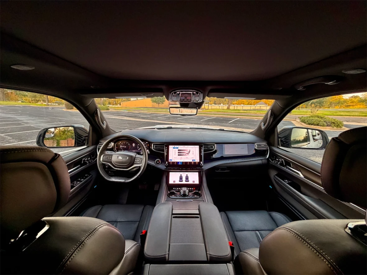 Interior view of a modern car showcasing the dashboard, steering wheel, and touchscreen display with black leather seats.