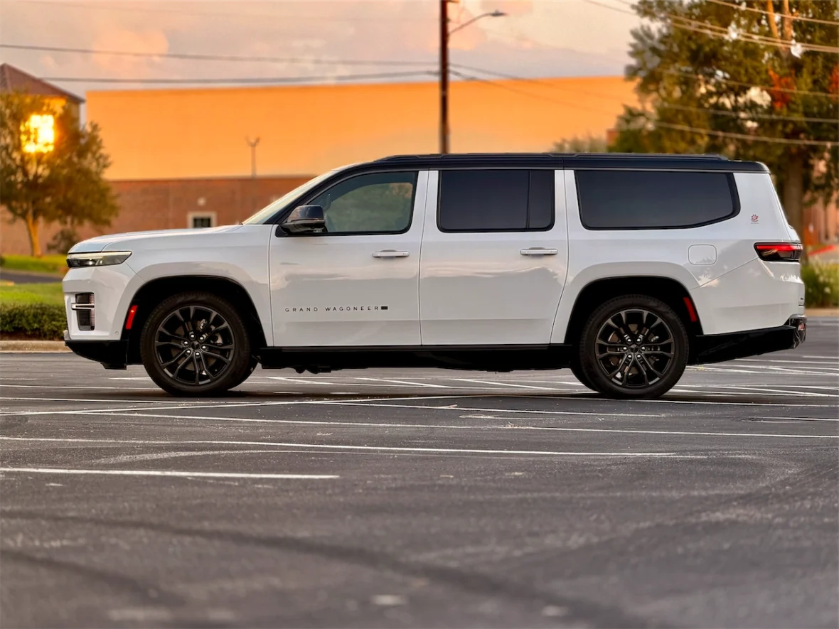 The 2026 Jeep Grand Wagoneer L parked on a flat surface, showcasing a sleek design with a modern aesthetic and black alloy wheels.