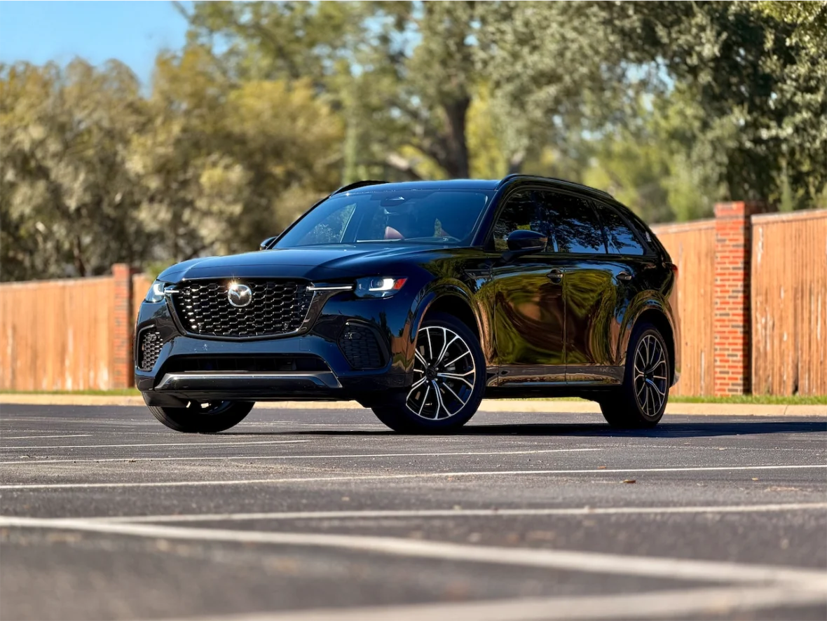 A black SUV parked in an empty lot, showcasing its sleek design and shiny exterior under natural light.
