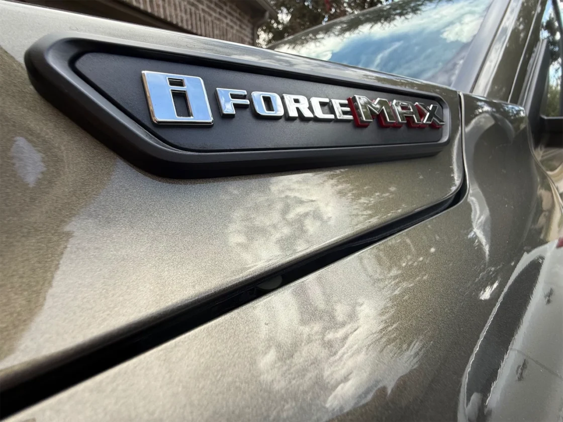 Close-up of a vehicle badge displaying 'i FORCE MAX' on a metallic surface.