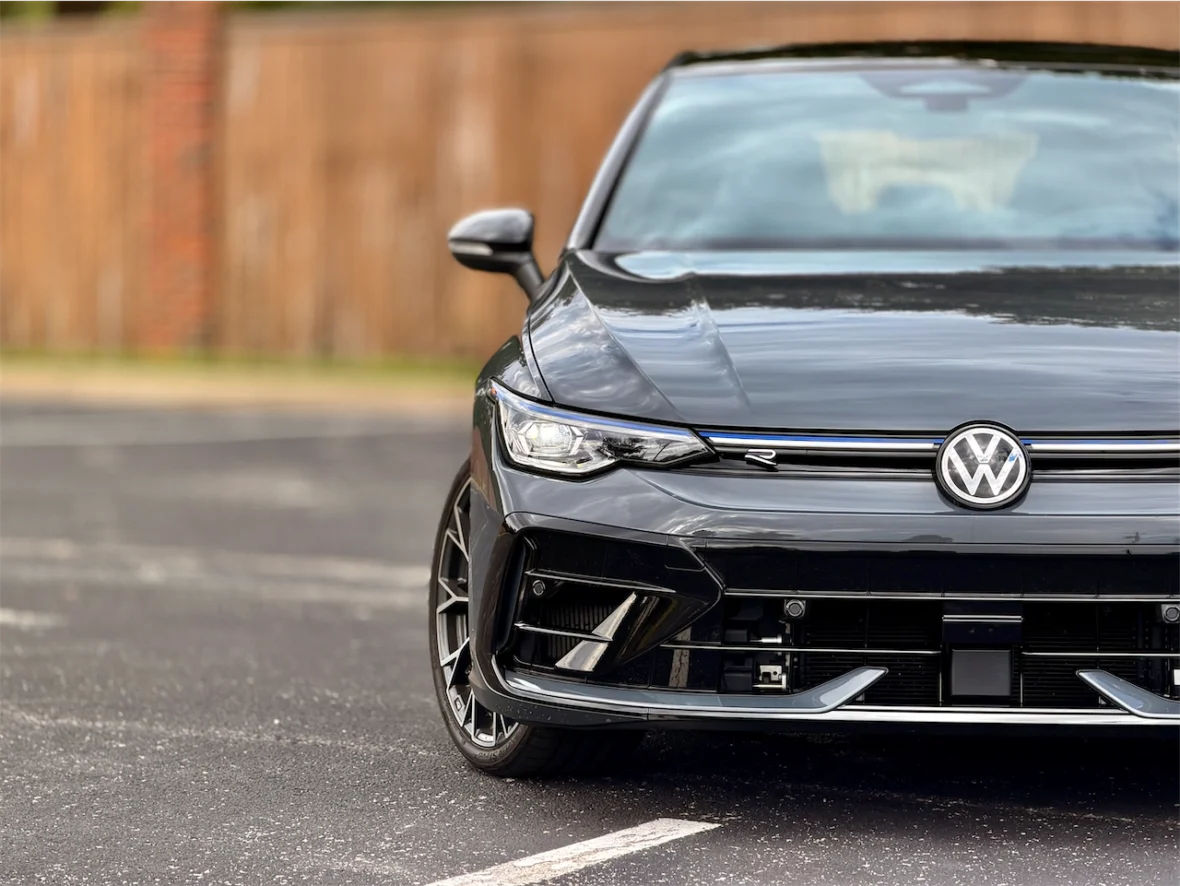 A close-up view of a black Volkswagen car, showcasing its sleek front design and prominent logo.