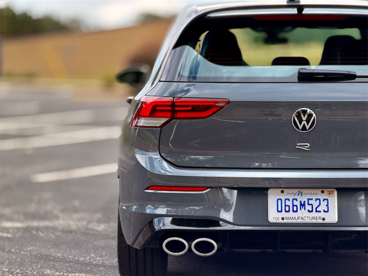 Rear view of a grey Volkswagen R vehicle, showcasing its distinctive taillights and dual exhaust pipes.