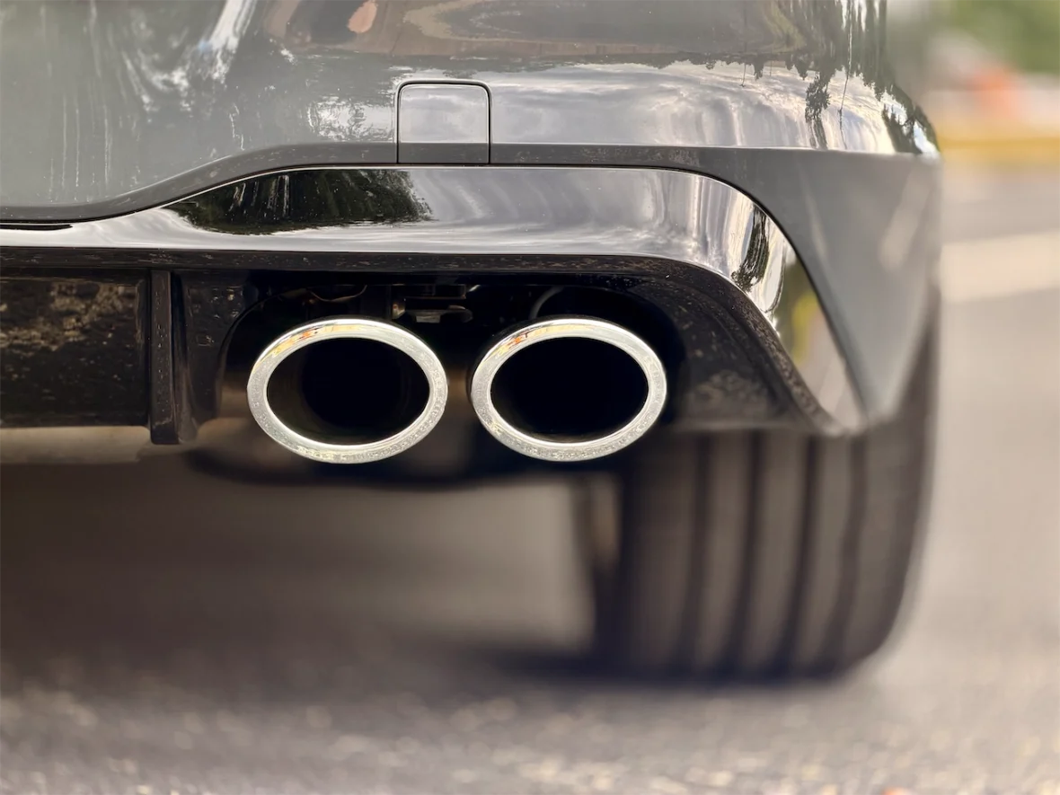 Close-up view of a car's dual exhaust pipes attached to the rear bumper.