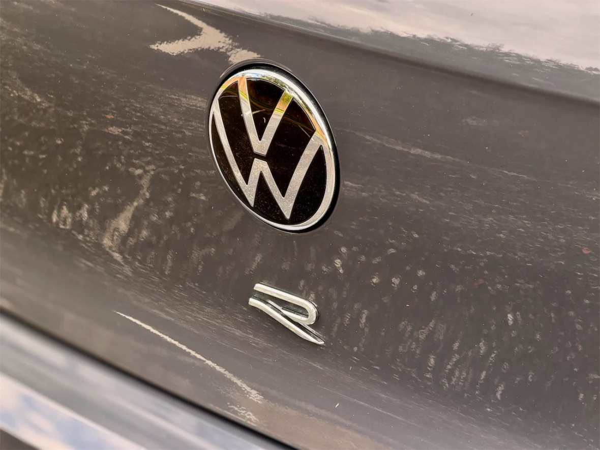 Close-up of a gray car's trunk featuring the Volkswagen logo and 'R' badge.