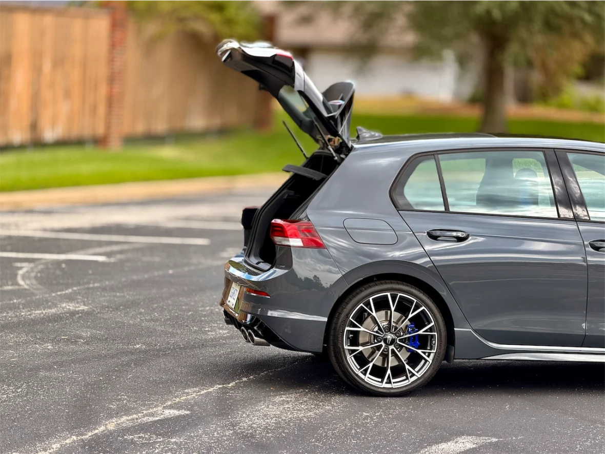 A gray hatchback car parked with its trunk open, showcasing its interior and sleek design.