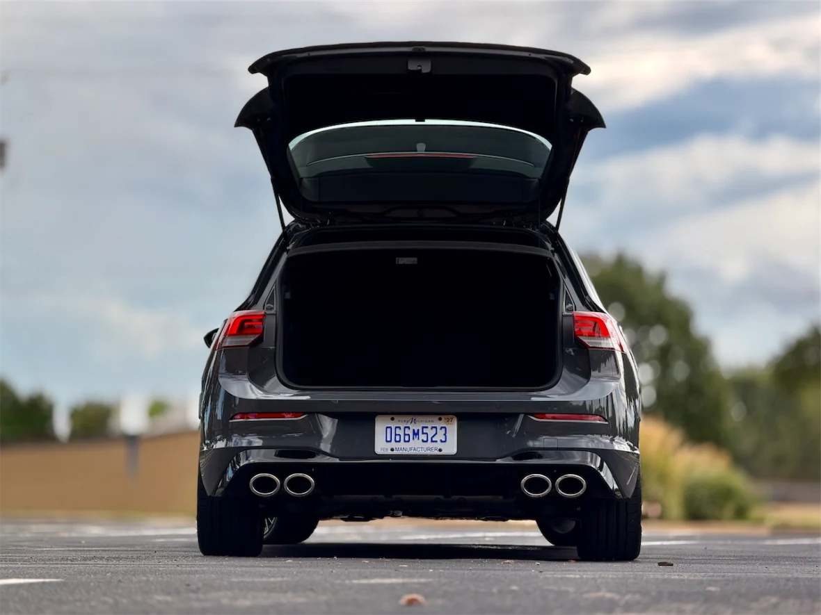Rear view of a gray car with the trunk open, showcasing the empty cargo space.