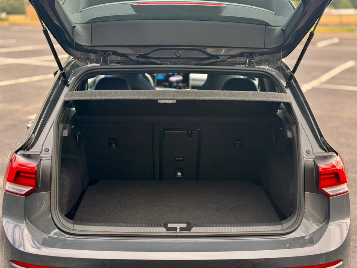 Open trunk of a gray car showing ample storage space with a flat, carpeted floor.