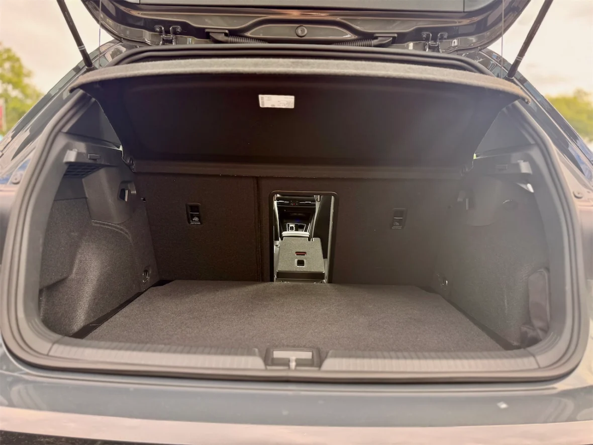Interior view of a car's trunk with the door open, showing the spacious cargo area featuring a flat floor and side compartments.