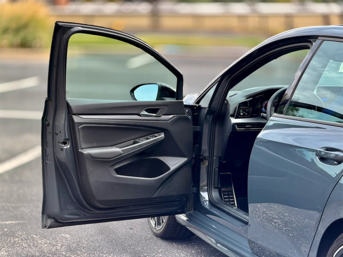 Close-up of a car's front door open, showing the interior design and controls.