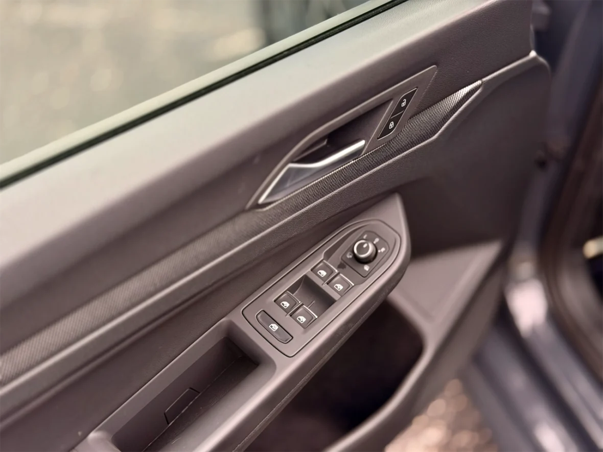 Close-up view of a car door panel featuring window and door lock controls.