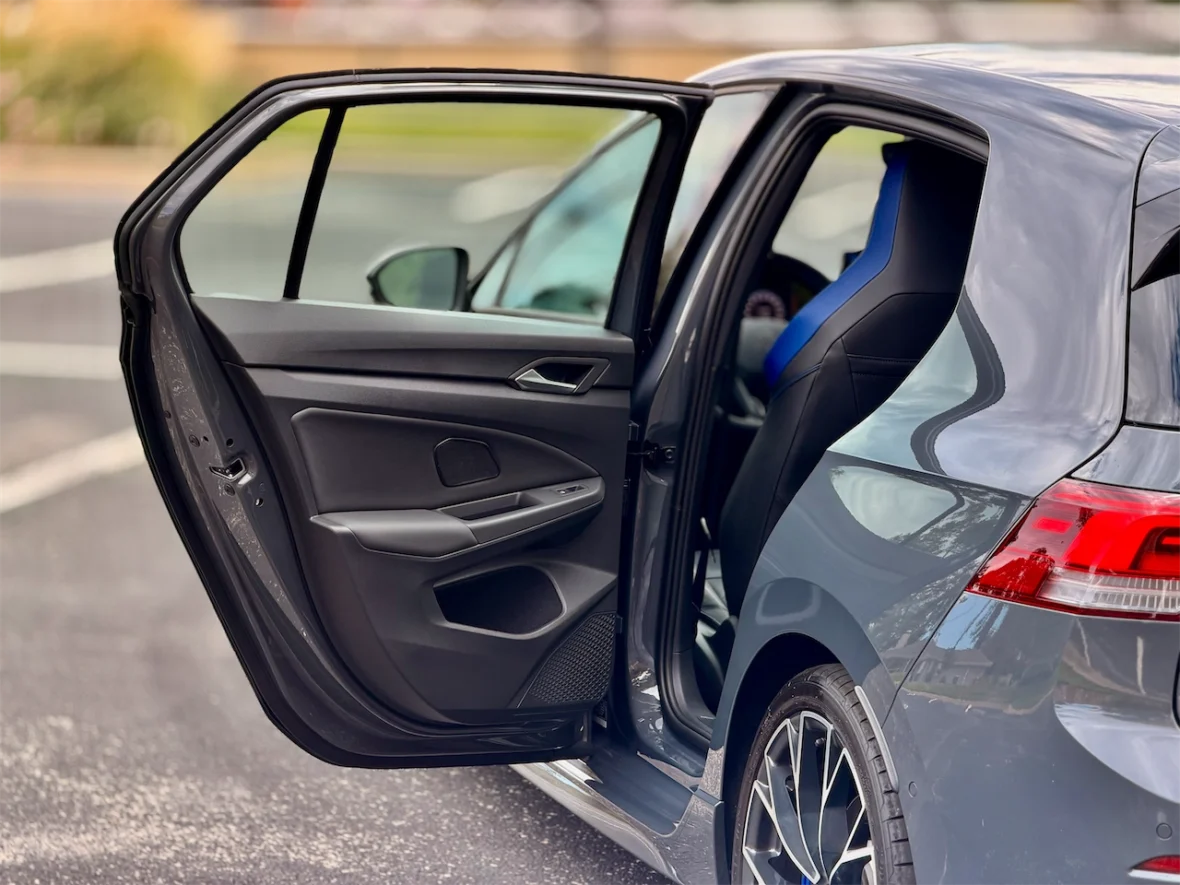 Open car door revealing the interior with a blue and black seat.