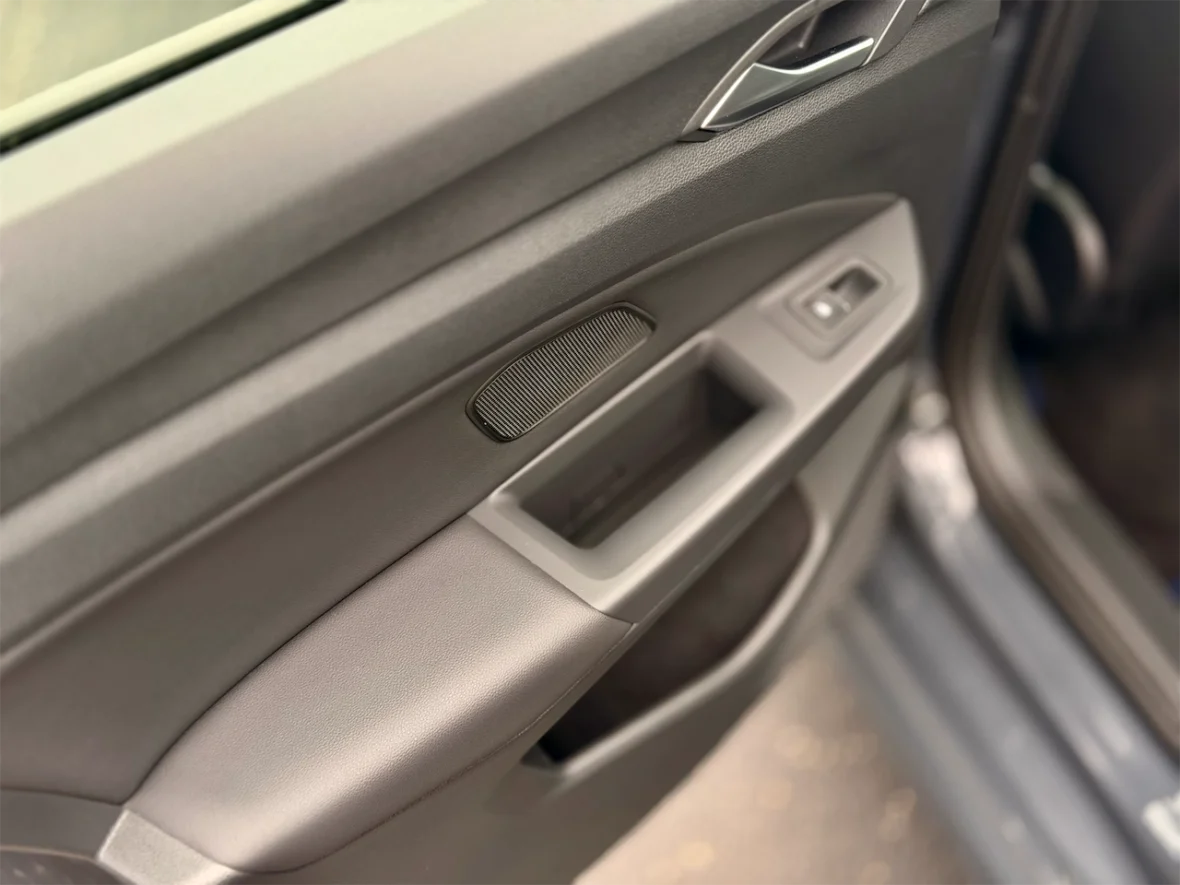 Close-up view of a car door interior showing the door handle and armrest design.