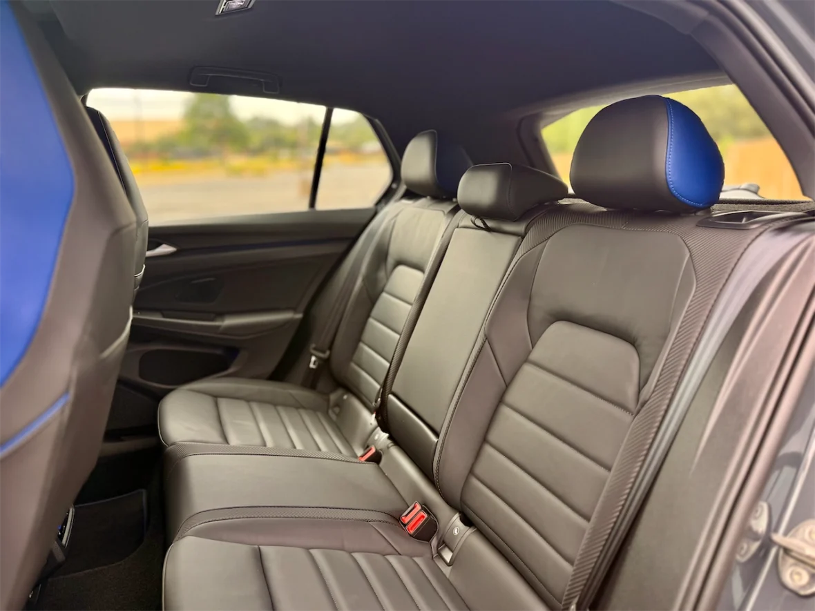 Interior view of a car's back seat featuring black leather upholstery and blue accents.