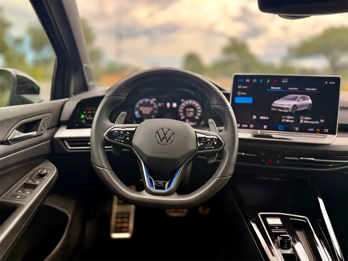 Interior view of a Volkswagen car, featuring a modern steering wheel, digital dashboard, and touchscreen display.