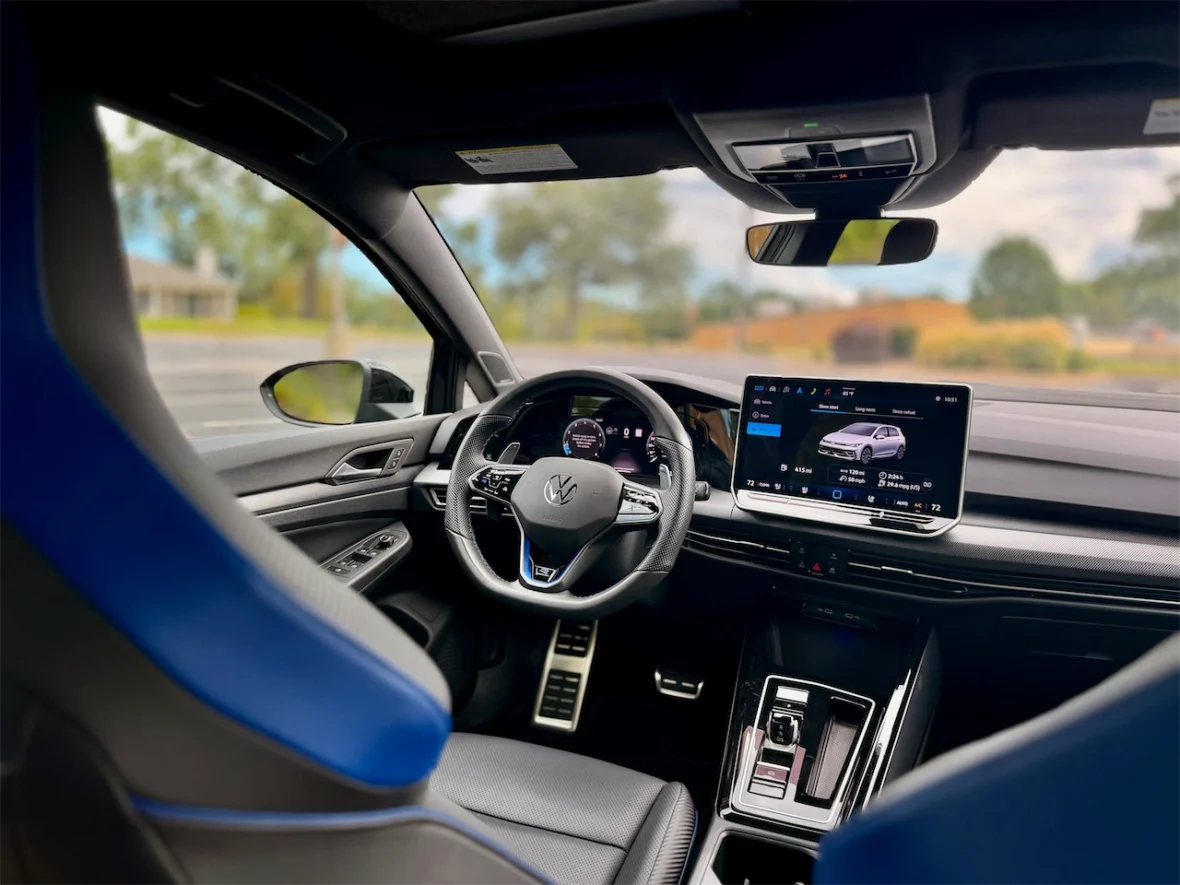 Interior view of a modern car showcasing the steering wheel, digital dashboard, and infotainment screen with navigation features.
