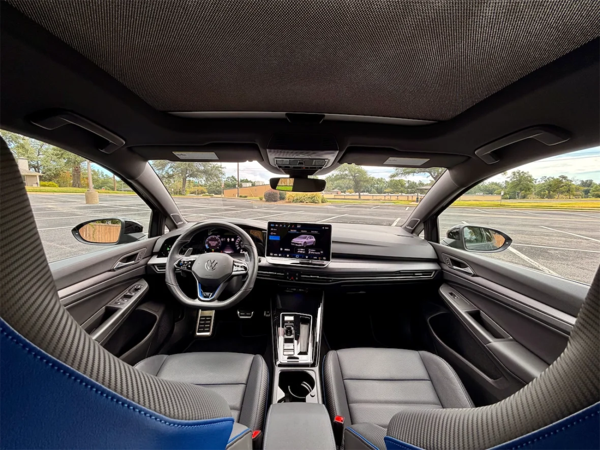 Interior view of a modern car, showcasing the dashboard, steering wheel, and front seats with a sleek design and technology display.