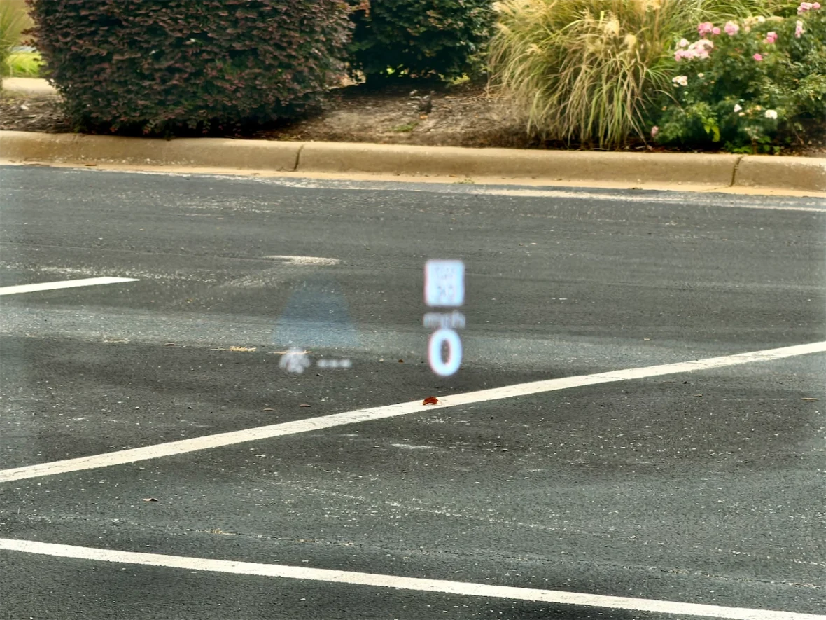 A parking lot with a digital display showing speed and distance metrics on the pavement.