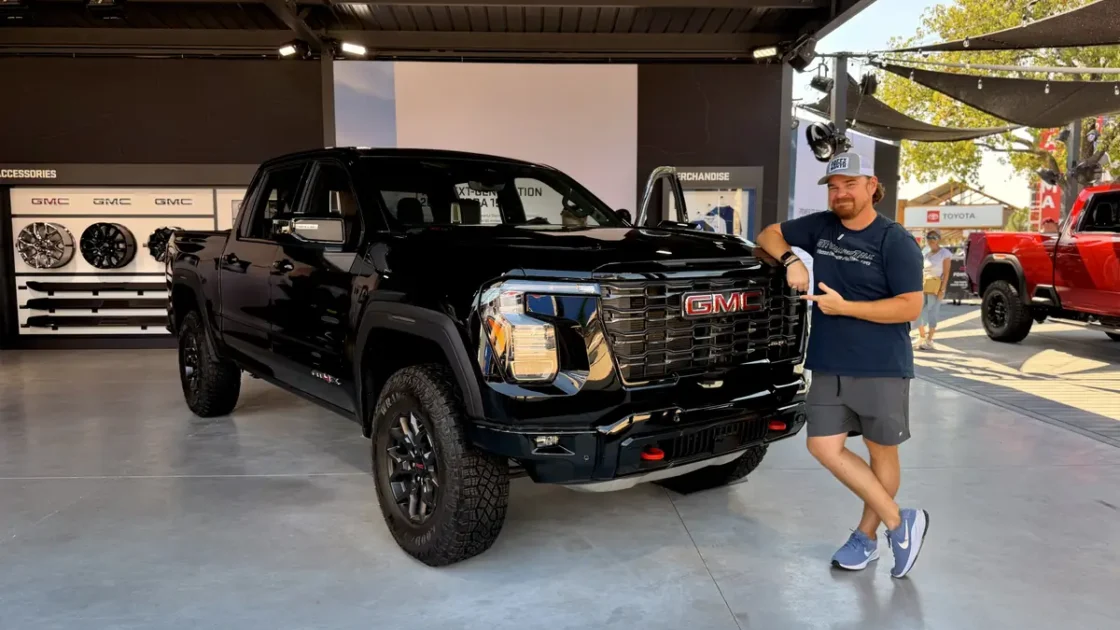 Cory Fourniquet points to the grille of a black 2027 GMC Sierra AT4X at the State Fair of Texas