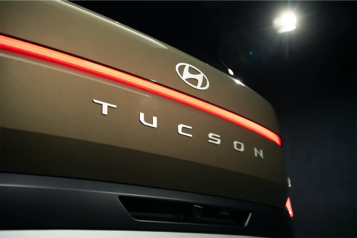 Close-up of the rear of a Hyundai Tucson showing the logo and illuminated model name in a sleek design.