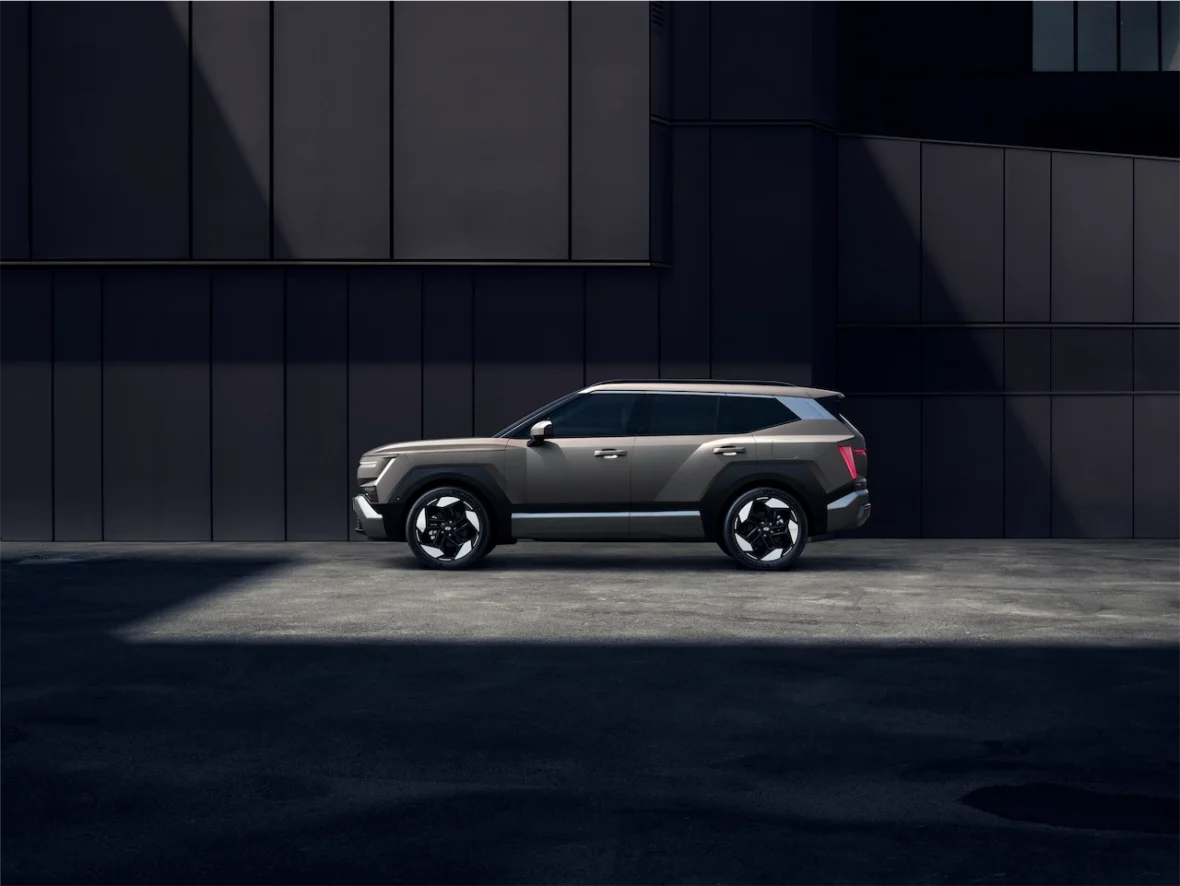A modern SUV parked against a dark, geometric backdrop, showcasing its sleek design and stylish features.