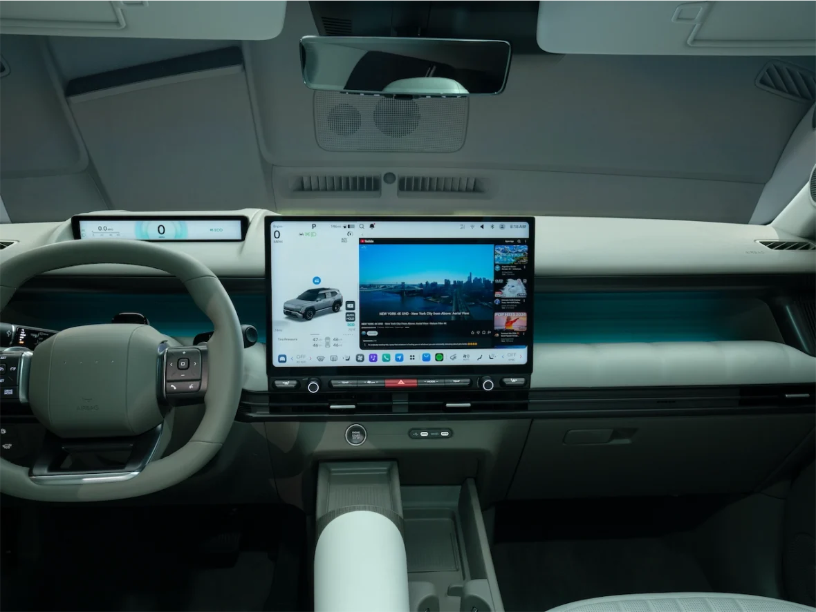 Interior view of a modern car showcasing a sleek dashboard with a large touchscreen display, digital instrument cluster, and a multifunction steering wheel.