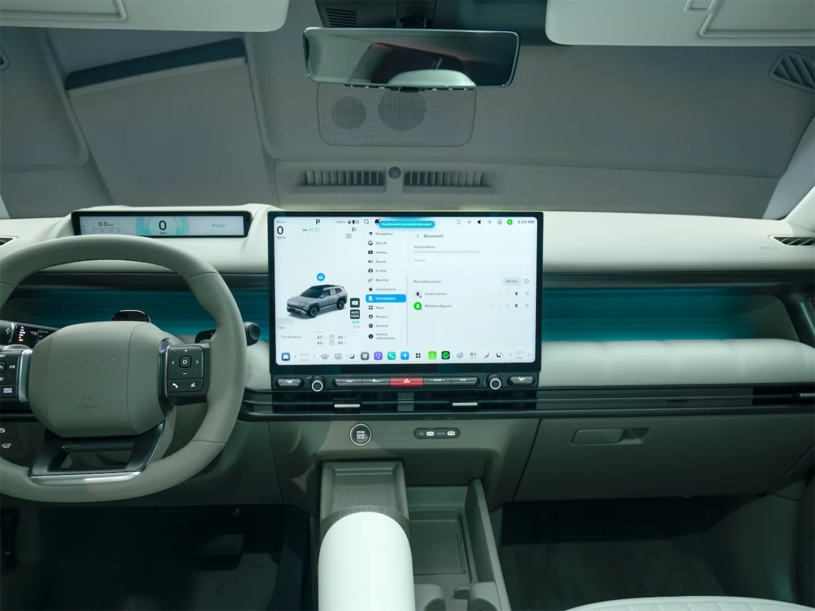 Interior view of a modern car showcasing a steering wheel and a large central touchscreen display with navigation and connectivity features.