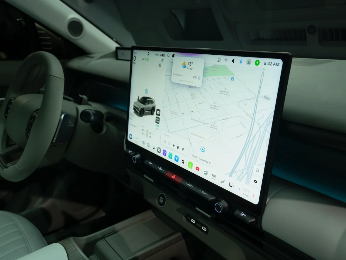 Interior view of a modern car dashboard featuring a large touchscreen display showing a map and vehicle information.