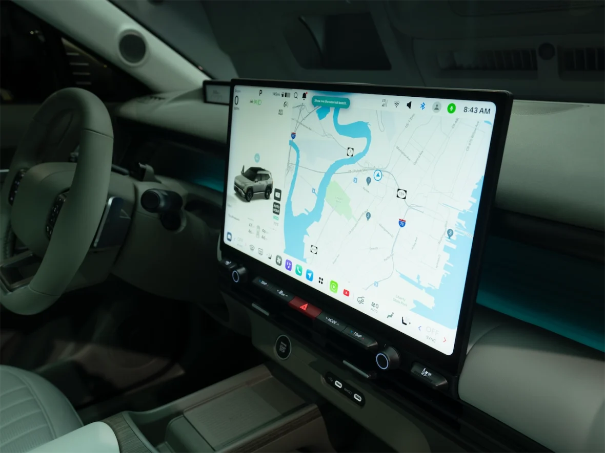 Interior view of a modern vehicle featuring a large touchscreen display showing a navigation map.