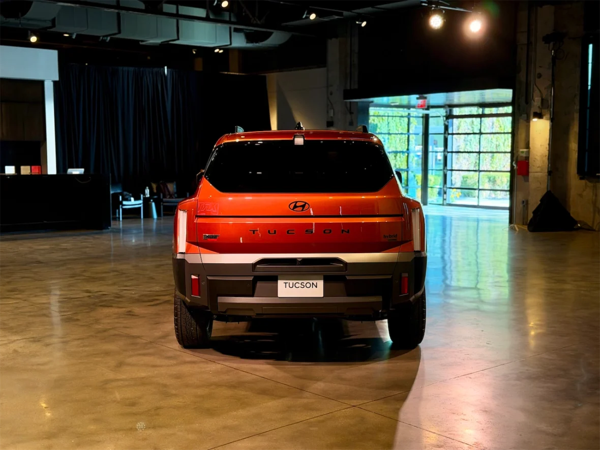 Rear view of a Hyundai Tucson SUV in an indoor setting with modern lighting and polished floors.