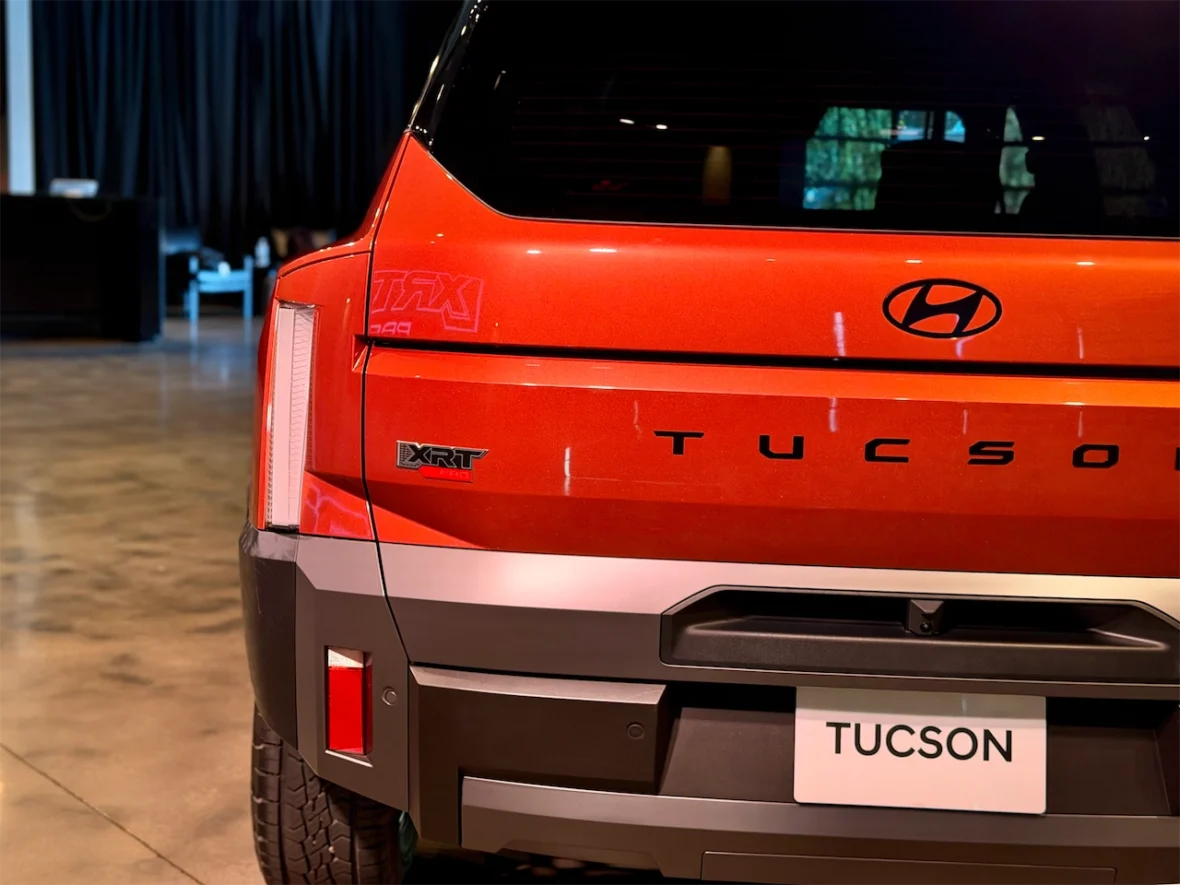 Rear view of a red Hyundai Tucson XRT SUV with a modern design in a stylish indoor setting.