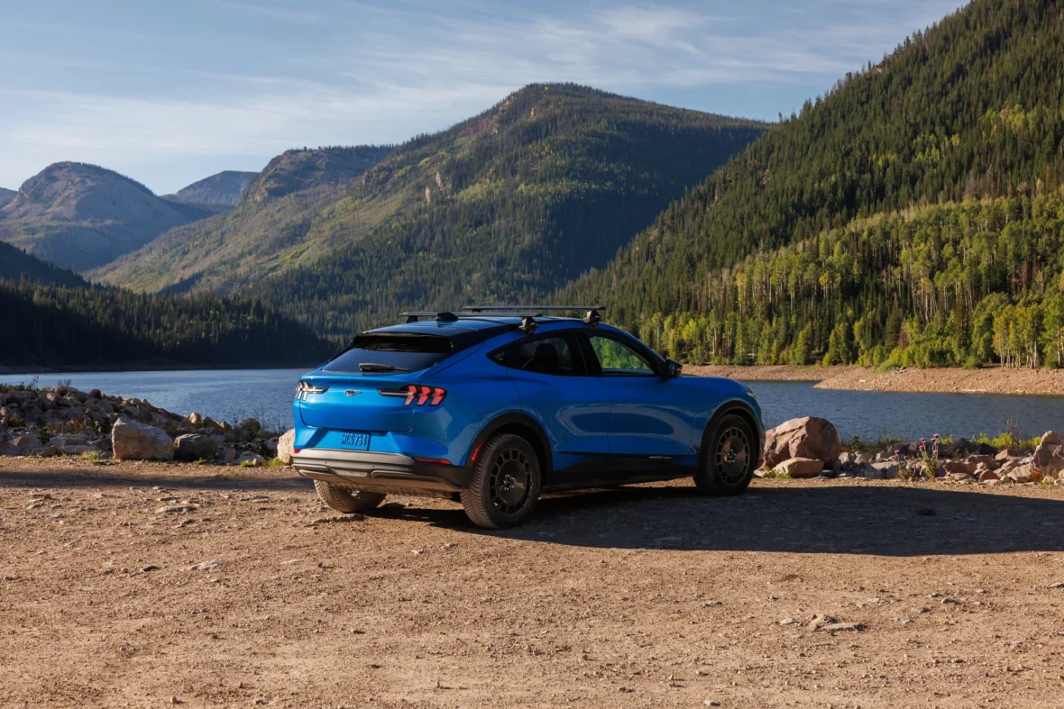 Blue electric crossover parked beside a mountain lake