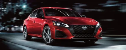 2027 Nissan Altima front three-quarter view parked on a city street at night