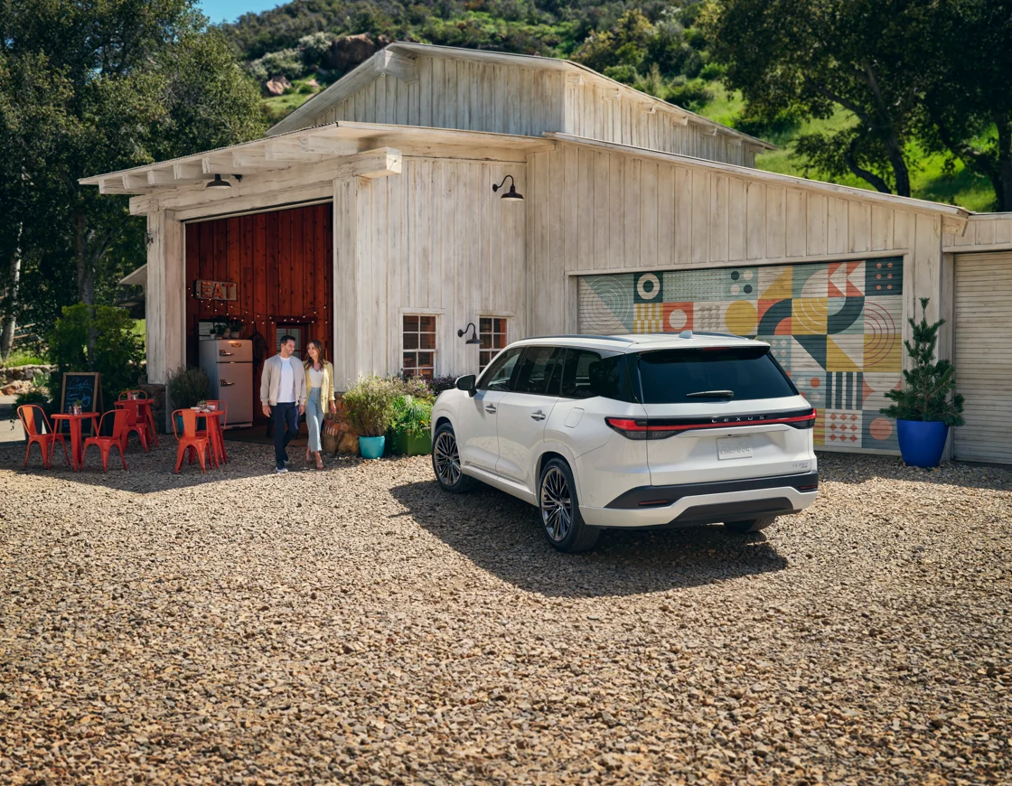 White 2027 Lexus TX parked outside a rustic building