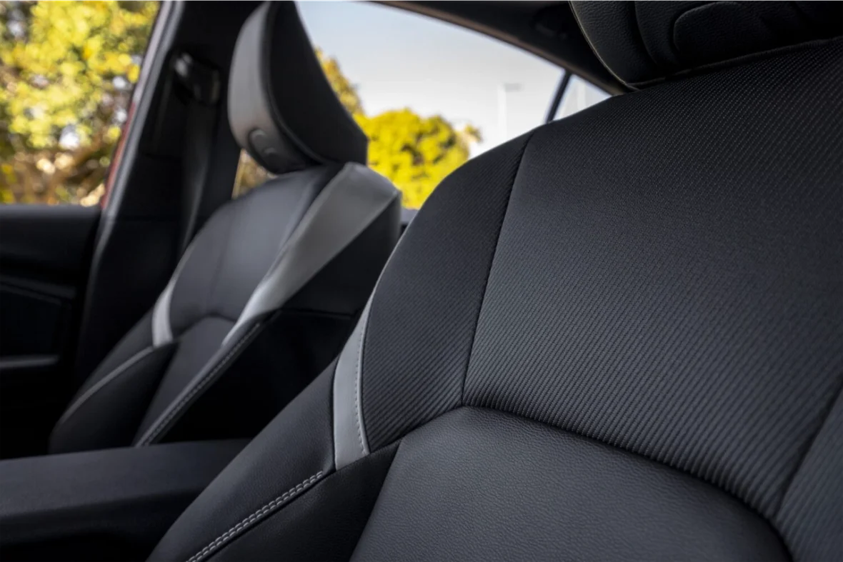 Close-up of modern car seats featuring a sleek black design with textured fabric and contrast stitching.